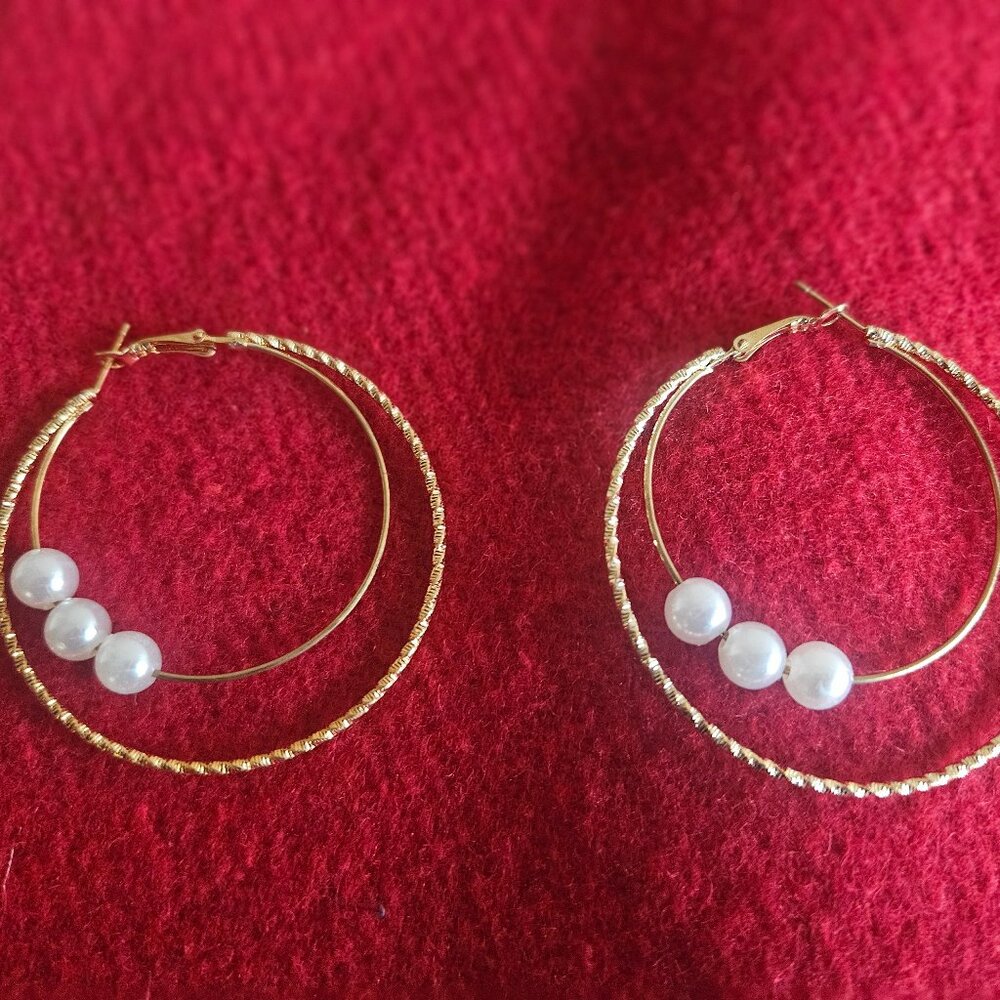 Lightweight gold hoop earrings with pearl balls.